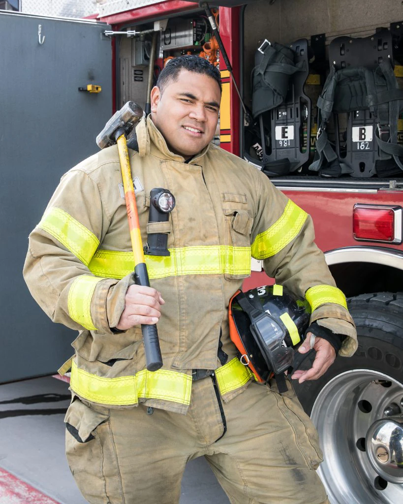 A firefighter with tools and helmit posing