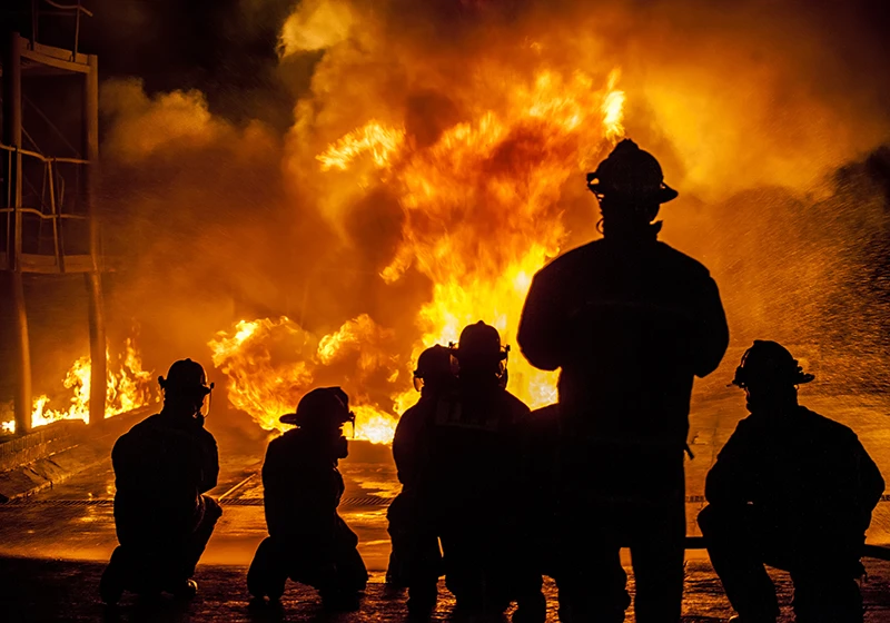 A silhouette of firefighters at a fire